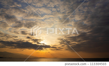 夕陽在傍晚的天空和許多雲彩中落下 113304503