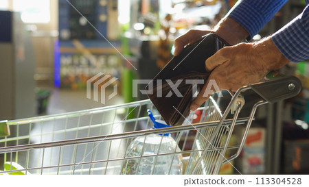 A grocery check in the hands of an elderly man A grocery check in the hands of an elderly man 113304528