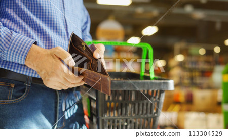 A grocery check in the hands of an elderly man A grocery check in the hands of an elderly man 113304529