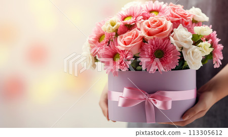 Close up of box with pink bouquet on gift box in female hands. Banner or gift card for Happy Mother's Day or Happy Women's day, birthday. 113305612