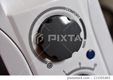 Round switches on a white radiator. The control panel. 113305865