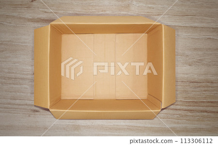 Opened cardboard box, top view, on wooden floor. Opened cardboard box, top view, on wooden floor. 113306112