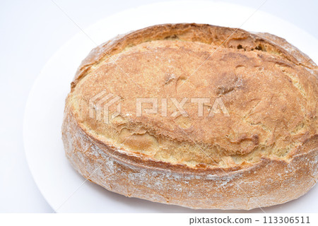 A fresh loaf of bread on a plate.  A piece of delicious bread. Bakery products. 113306511