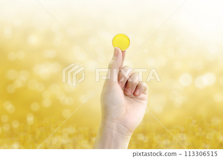 gold coin holding gold coin in hand on a blurred golden yellow bokeh background. 113306515
