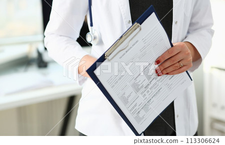 Female doctor hand holding and filling patient 113306624