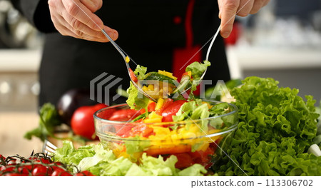 Cook holds fork in hand and mixes 113306702