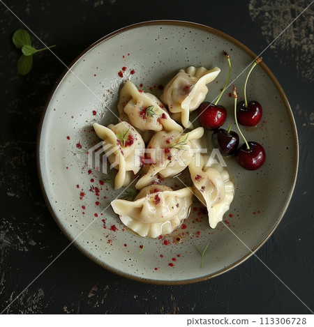 Dumplings with cherries on a plate with cherries on a black background 113306728