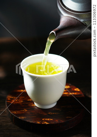 Green tea poured from a teapot Green tea poured from a teapot 113306972