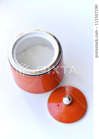 Red ceramic sugar bowl on a white background. Sugar in a jar. Red ceramic sugar bowl on a white background. Sugar in a jar. 113307290