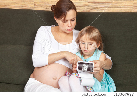 Expectant Mother and Daughter Looking at Ultrasound Expectant Mother and Daughter Looking at Ultrasound 113307688