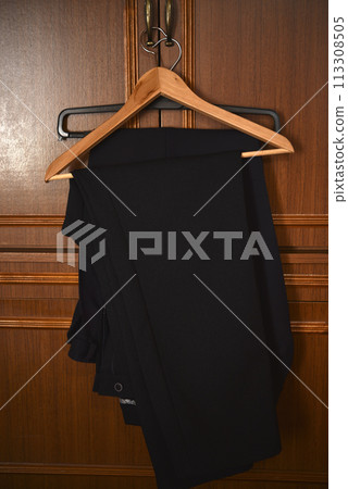 Pants on a wooden hanger. Folded blue trousers. 113308505