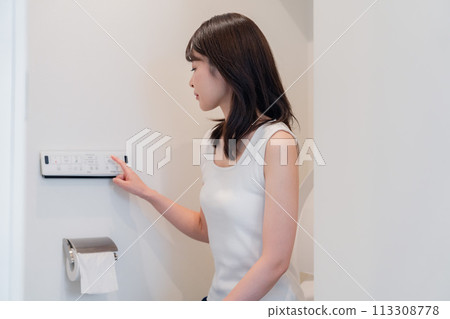 Young woman using a bidet Young woman using a bidet 113308778