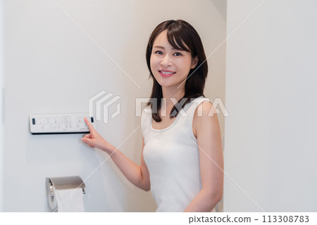 Young woman using a bidet Young woman using a bidet 113308783