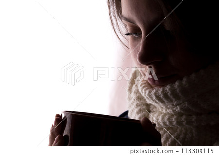 Silhouette of a young woman with a cup 113309115