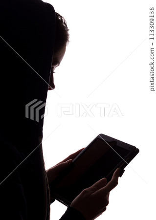 Silhouette of a girl in the hood with a tablet Silhouette of a girl in the hood with a tablet 113309138