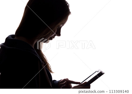 Silhouette of a girl in the hood with a tablet 113309140