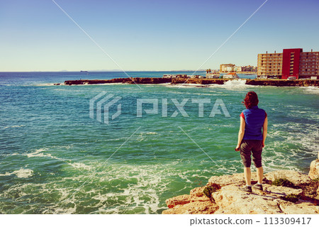 Tourist woman on sea cliffs in Spain Tourist woman on sea cliffs in Spain 113309417