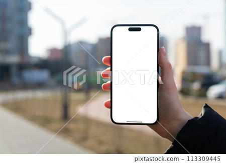 Berlin Germany January 21 2024 Hand holding mobile phone, iphone screen mockup, city background Berlin Germany January 21 2024 Hand holding mobile phone, iphone screen mockup, city background 113309445