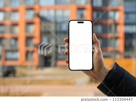 Berlin Germany January 21 2024 Hand holding mobile phone, iphone screen mockup, city building 113309447