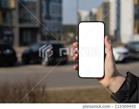 Holding mobile phone screen mockup, empty blank smartphone display, blurred city background Holding mobile phone screen mockup, empty blank smartphone display, blurred city background 113309450