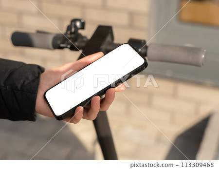 Hand using mobile phone screen mockup for renting e-scooter 113309468