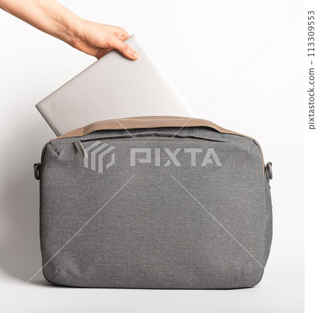 Hand taking laptop computer from notebook bag 113309553