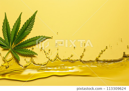 Cannabis leaf and cannabis yellow oil, long horizontal splash on background, studio shot style. For cosmetic products based on hemp with copy space for text 113309624