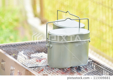 Cooking rice in a mess kit, cooking rice outdoors, outdoor, camping, image material 113309881