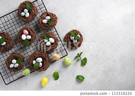 Easter chocolate cookies. Nests with sweet eggs on white background with mint leaves 113310220