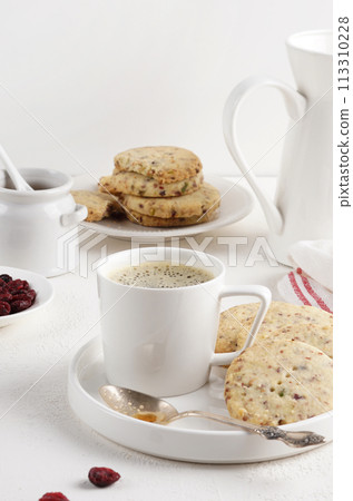 A cup of coffee with Cranberry shortbread cookies on the light table, morning breakfast, copy space 113310228