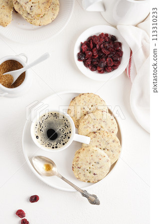 Cranberry shortbread cookies with coffee on the light table, morning breakfast, top view 113310233