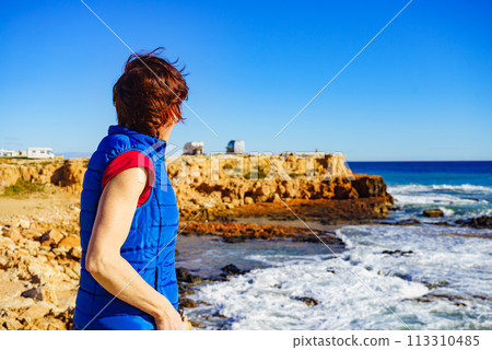 Tourist woman on sea cliffs in Spain Tourist woman on sea cliffs in Spain 113310485