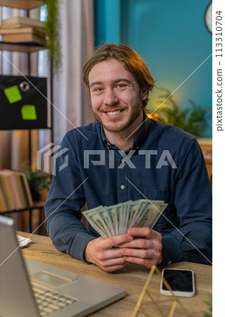 Rich businessman guy holding fan of cash money dollar banknotes showing thumbs up online income Rich businessman guy holding fan of cash money dollar banknotes showing thumbs up online income 113310704