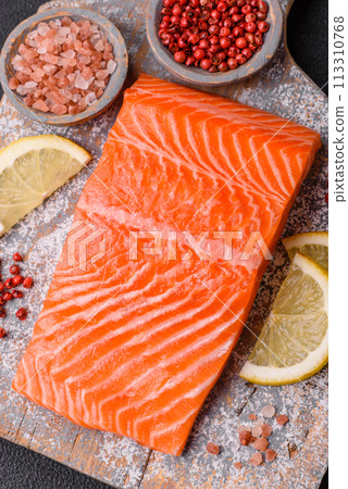 Fresh raw salmon steak with spices and herbs prepared for grilled baking 113310768