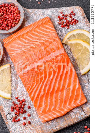 Fresh raw salmon steak with spices and herbs prepared for grilled baking 113310772