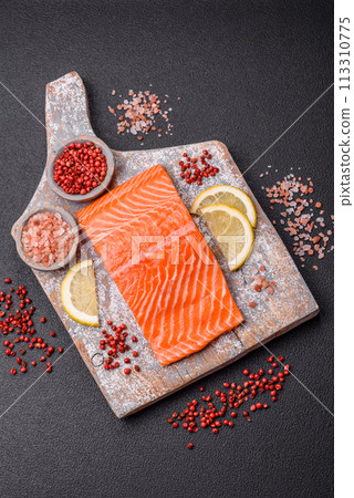 Fresh raw salmon steak with spices and herbs prepared for grilled baking 113310775