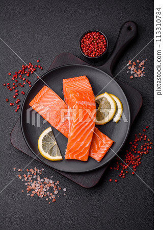Fresh raw salmon steak with spices and herbs prepared for grilled baking Fresh raw salmon steak with spices and herbs prepared for grilled baking 113310784