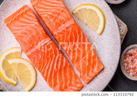 Fresh raw salmon steak with spices and herbs prepared for grilled baking Fresh raw salmon steak with spices and herbs prepared for grilled baking 113310792
