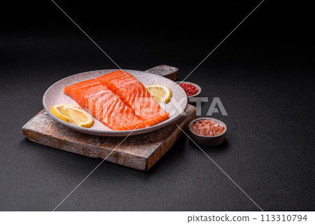Fresh raw salmon steak with spices and herbs prepared for grilled baking 113310794