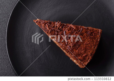 Delicious fresh cheesecake cake or snickers with cream and nuts on a ceramic plate 113310812