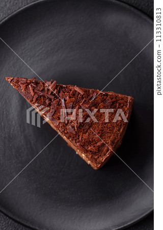 Delicious fresh cheesecake cake or snickers with cream and nuts on a ceramic plate 113310813