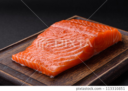 Fresh raw salmon steak with spices and herbs prepared for grilled baking Fresh raw salmon steak with spices and herbs prepared for grilled baking 113310851