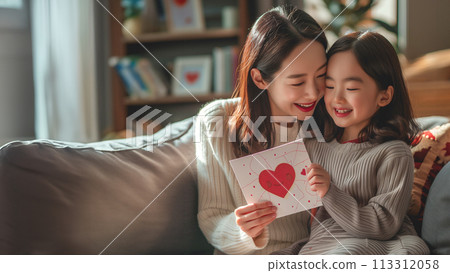 A tender moment between a smiling mother and her joyful daughter 113312058