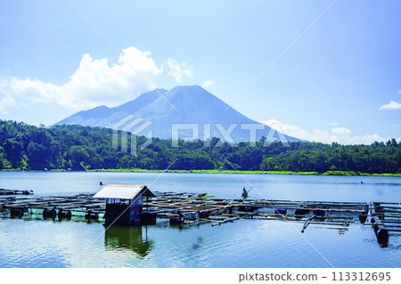 a majestic volcano with a calm lake in front of it. a majestic volcano with a calm lake in front of it. 113312695