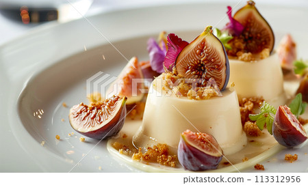 A gourmet panna cotta dessert garnished with fresh fig slices and served with a rich berry coulis. 113312956