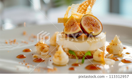 A gourmet panna cotta dessert garnished with fresh fig slices and served with a rich berry coulis. 113312957