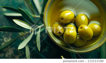 Mediterranean delicacy, ripe yellow olives against the background of olive branches. 113313190