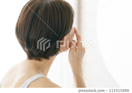 Back view of a middle-aged woman doing skin care 113315899
