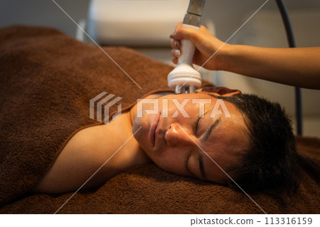 一位男士在男士美容沙龍接受空化臉部美容(皮膚護理/臉部線條) 一位男士在男士美容沙龍接受空化臉部美容(皮膚護理/臉部線條) 113316159