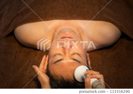 A man receiving facial treatment using cavitation at a men's beauty salon (skin care) A man receiving facial treatment using cavitation at a men's beauty salon (skin care) 113316290